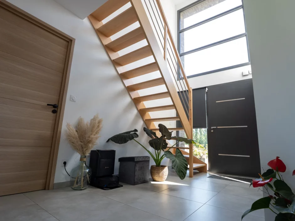 Entrée et escalier éclairés par la fenêtre toute hauteur